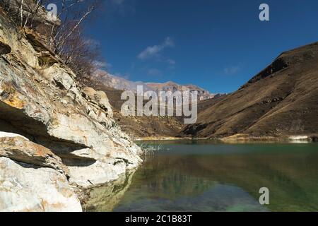 Landschaft Bergsee. Natürlicher hoher Stausee mit epischen Felsen im Hintergrund. Nordkaukasus. Russland. Bylhum Dorf Stockfoto