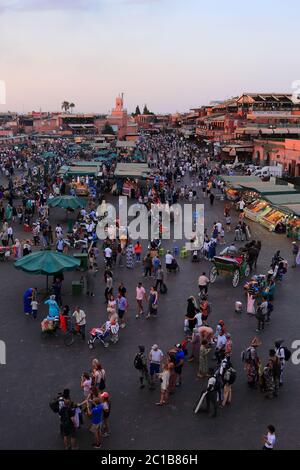 Marokko, Marrakesch. Abenddämmerung auf dem Djemaa el Fna Platz. Nachts verwandelt sich der Platz in ein riesiges Restaurant unter freiem Himmel und eine Vielzahl von Aktivitäten. Stockfoto