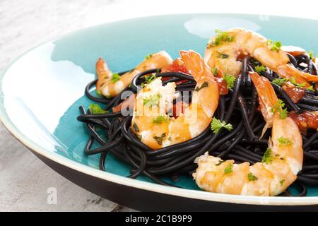 Köstliche schwarze Spaghetti mit Garnelen Stockfoto