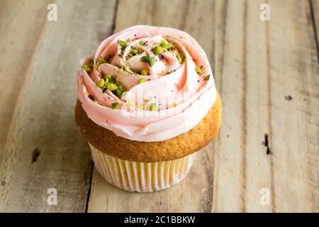 Rosa Cup Cake auf rustikalen Holztisch Nahaufnahme Stockfoto