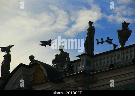 Ein Link von Militärflugzeugen fliegt über die Eremitage und hinterlässt einen umgekehrten Weg Stockfoto