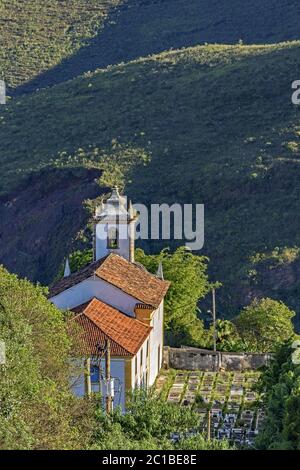 Blick auf die alte Kirche in der Stadt Ouro Preto mit einem Friedhof daneben Stockfoto