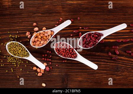 Verschiedene frische Hülsenfrüchte in Löffel Stockfoto