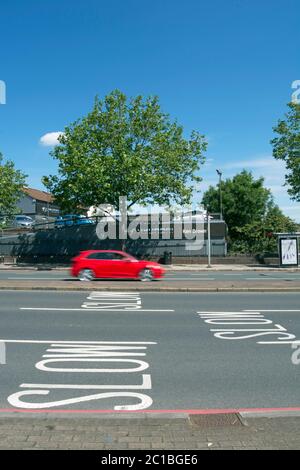 Straßenmarkierungen Warnung Verkehr zu langsam, auf der Annäherung an Manor Zirkus Kreisverkehr, East Sheen, Südwesten london, england, mit Auto in unscharfer Bewegung Stockfoto