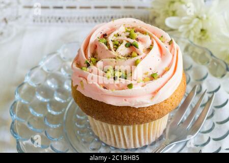 Rosa Buttercreme Eisbecher Kuchen Nahaufnahme auf Glasplatte Stockfoto