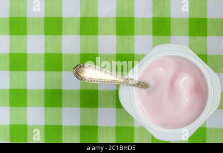 Rosa Joghurt im Becher mit Löffel schließen - Ansicht von oben Foto mit Platz für Text Stockfoto
