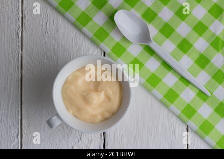 Gesunde Pfirsich / Aprikosen-Frucht aromatisierten Joghurt mit natürlicher Färbung in kleinen weißen Tasse isoliert auf Stockfoto