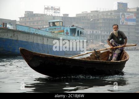 Sadarghat in Dhaka, Bangladesch. Ein Mann rudert sein kleines Boot über den Fluss bei Sadarghat in Dhaka. Stockfoto