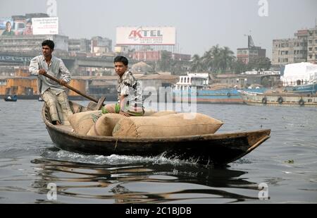 Sadarghat in Dhaka, Bangladesch. Ein Mann rudert sein kleines Boot über den Fluss bei Sadarghat in Dhaka mit Säcken. Stockfoto