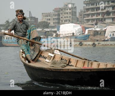 Sadarghat in Dhaka, Bangladesch. Ein Mann rudert sein kleines Boot über den Fluss bei Sadarghat in Dhaka. Stockfoto