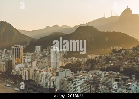 Sonnenuntergangsansicht in Copacabana, Wohngebäude, Favela Babilonia, Berge und Corcovado mit Christus Statue, in Rio de Janeiro, Brasilien Stockfoto