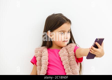 Portrait von kleinen Mädchen, die ein Selfie isoliert auf weißem Hintergrund Stockfoto