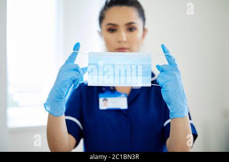 Pflegekraft, die eine PSA-Maske aufsetzt Stockfoto