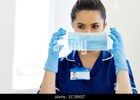 Pflegekraft, die eine PSA-Maske aufsetzt Stockfoto