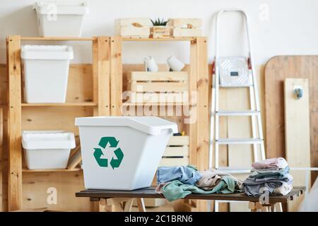 Bild von großen Plastikbehälter und alte Kleidung auf dem Tisch im Lagerraum Stockfoto