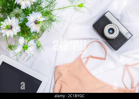 Flache Lay-Komposition von Blogger-Arbeitsbereich mit Blumen, Tablet, Tuch und Vintage-Kamera Stockfoto