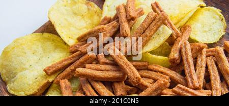 Banner mit Lebensmitteln und Snacks, leckere Kartoffelchips und gesalzene Roggenbrot Cracker aus der Nähe. Stockfoto