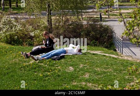 Umea, Norrland Schweden - 29. Mai 2020: Zwei Studentinnen faulenzen auf dem Campus in der Sonne Stockfoto