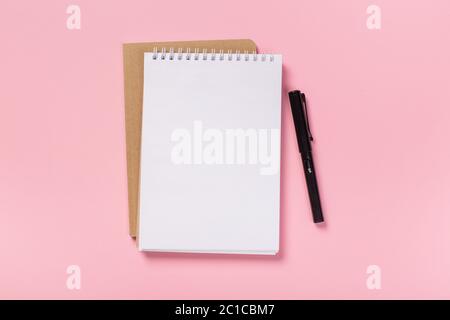 Schulheft auf rosa Hintergrund, Spiralnotizblock auf einem Tisch. Flatlay Stockfoto