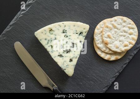 Rochefort Käse und Cracker aus der Nähe Draufsicht auf schwarzem Schieferbrett Stockfoto