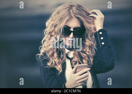 Mode Business Frau in Sonnenbrille mit Smartphone in der Stadt Straße Stockfoto