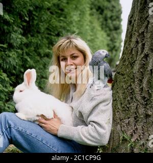 Die ehemalige britische olympische Turnerin Suzanne Dando fotografierte zu Hause mit ihrem Haustier Kaninchen und Papagei Stockfoto