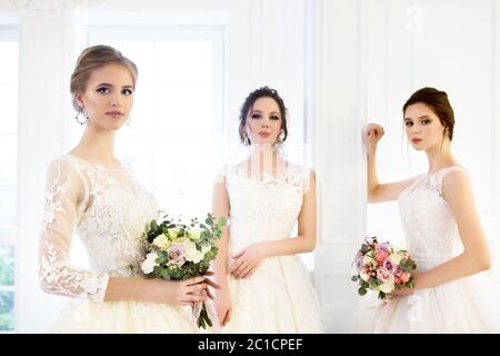 Junge Frau mit Blumensträußen tragen Brautkleider Stockfoto