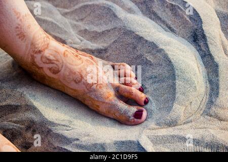 Ein Fuß zeigt Henna auf einem Sand Stockfoto