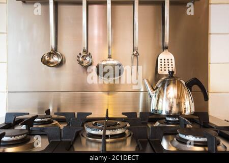 Eine Edelstahlpfanne voll kochendem Wasser auf einem Gasherd in einer modernen Küche. Stockfoto