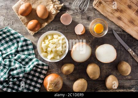 Spanische Omelette Tortilla Zutaten: Eier, Kartoffeln und Zwiebeln auf Holztisch Stockfoto