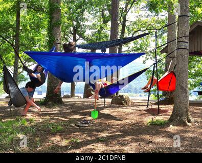 Cartersville, GA-circa 18. Mai 2019: Junge Jungs und Mädchen lachen und spielen zusammen und haben Spaß beim Schaukeln in Hängematten am See auf Red Top Mounta Stockfoto