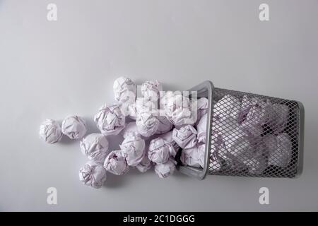 Ein Papierkorb voller zerknittertes Papier auf weißem Hintergrund in Nahaufnahme Stockfoto