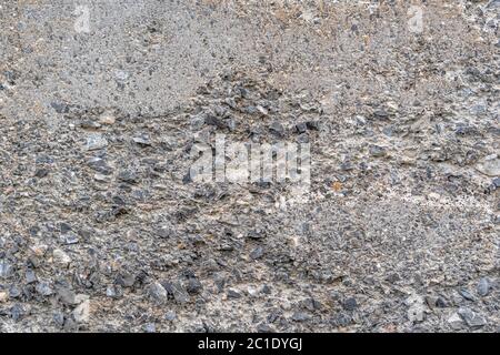 Alte Beton zerstörte Wand mit Beulen und Risse. Grauer abstrakter Hintergrund Stockfoto