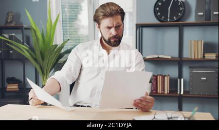 Konzentrierter Geschäftsmann mit Papieren Stockfoto