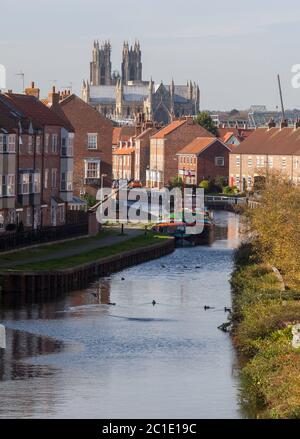 Blick auf Beverley Beck, einen Kanal, der Beverley, East Yorkshire, mit Syntan, einem restaurierten Binnenschiff auf dem Kanal und Beverley Mister im Hintergrund Stockfoto