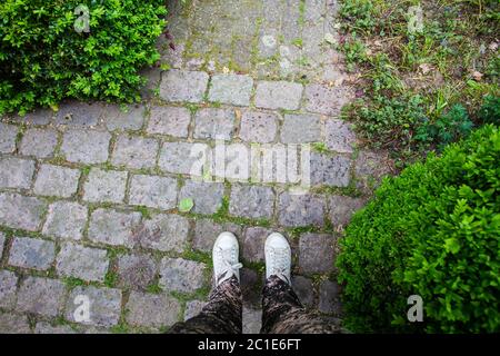 Nahaufnahme von Sneakerschuhen auf einer gepflasterten Straße Stockfoto