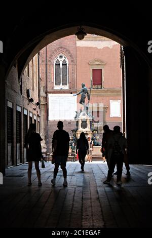 Silhouetten von Touristen in der Galerie unter dem König Enzo Palast, mit auf Hintergrund der Neptun Brunnen in Bologna, Italien Stockfoto