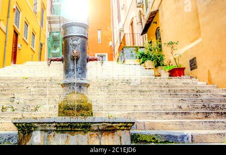 Alte gusseiserne Brunnen vor einer alten Treppe in Rom Stockfoto