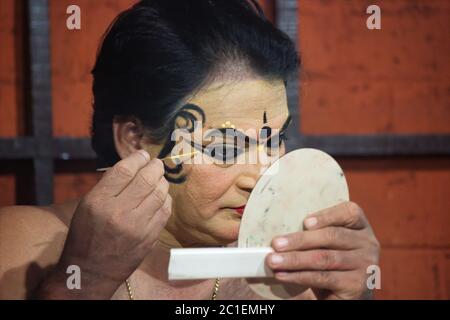 Ein Mann macht sich selbst Make-up vor kathakali Performance, die eine indische Form des klassischen Tanzes über Geschichte erzählen durch Gesten in Kerala, Indien Stockfoto