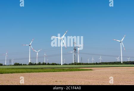 Freileitungen und moderne Windkraftanlagen in den Feldern in Deutschland Stockfoto