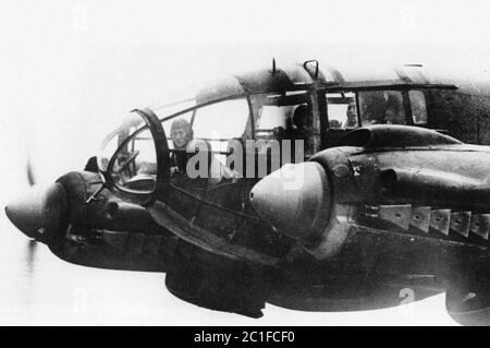 Ein Vorwärtskanonier sitzt an seiner Kampfposition in der Nase eines deutschen Heinkel He 111 Bombers, während er im November 1940 nach England unterwegs war. Stockfoto
