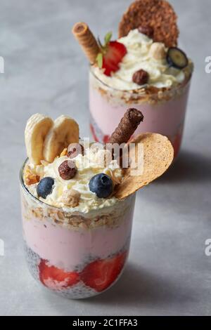 Müsli Joghurt Parfait mit frischen Beeren in Glas Tassen. Stockfoto