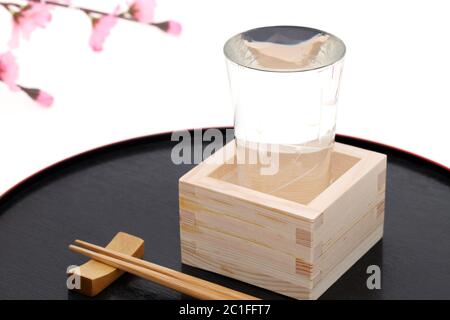 japanische Holzbox Masu mit Sake isoliert auf weißem Hintergrund Stockfoto