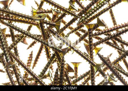 Viele goldene Messingschrauben auf weißem Hintergrund Stockfoto