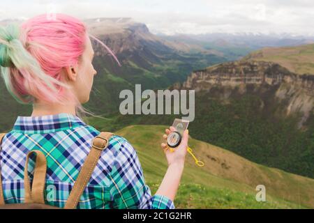 Ein Hipster-Mädchen reiste mit einem Blogger in einem karierten Hemd und mit bunten Haaren mit einem Kompass im Hintergrund im Bac Stockfoto