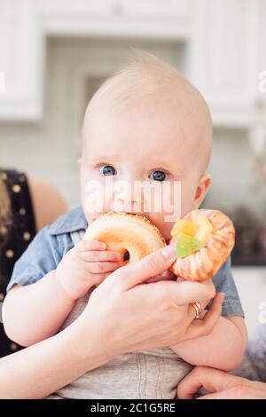 Baby junge Kleinkind essen süße Donut Stockfoto