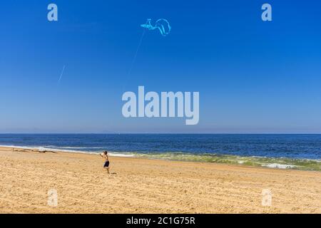 Boy startet einen Drachen am Strand Stockfoto