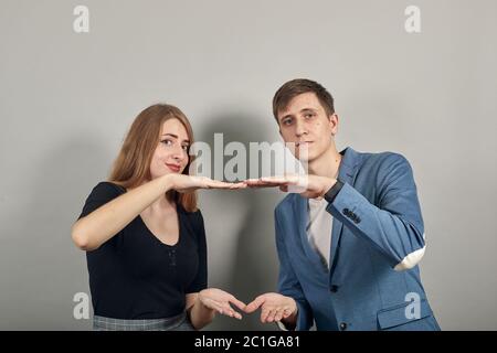 Formt mit zwei Händen ein großes Objekt, schnappt nach Überraschung und hält die Palmen vor sich Stockfoto