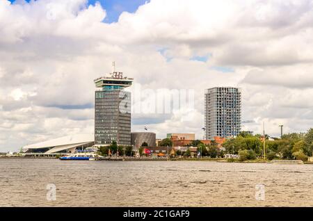 AMSTERDAM, HOLLAND - 31. AUG 2019: Panoramasicht auf den Fluss Amsterdam IJ mit Fähren, EYE Film Museum, ADAM Tower und modernen Gebäuden. Stockfoto