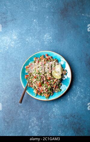 Traditionelle libanesische Salattabouli mit Quinoa, Kräutern, Tomaten, Minze und Zitrone Stockfoto